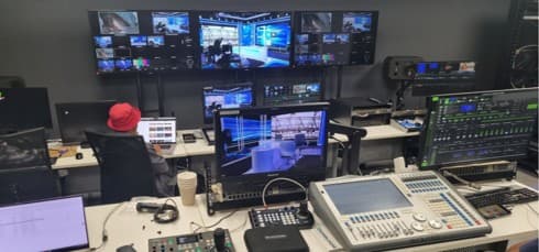 Broadcast studio control room with multiviewer screens, vision and lighting desks